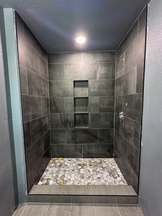 Bathroom remodel with blue vanity and custom tile shower