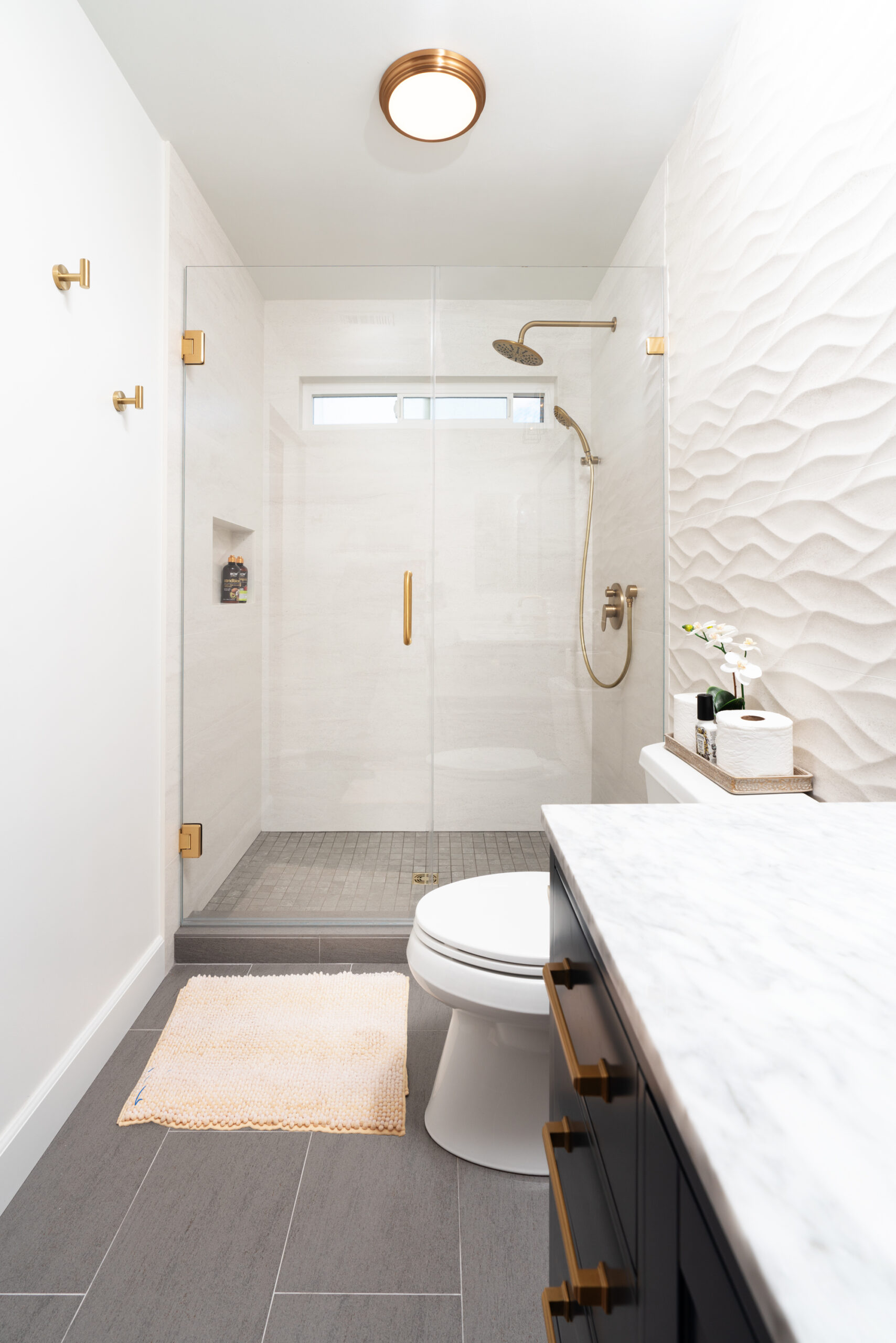 Walk-in shower with white tile walls and glass enclosure