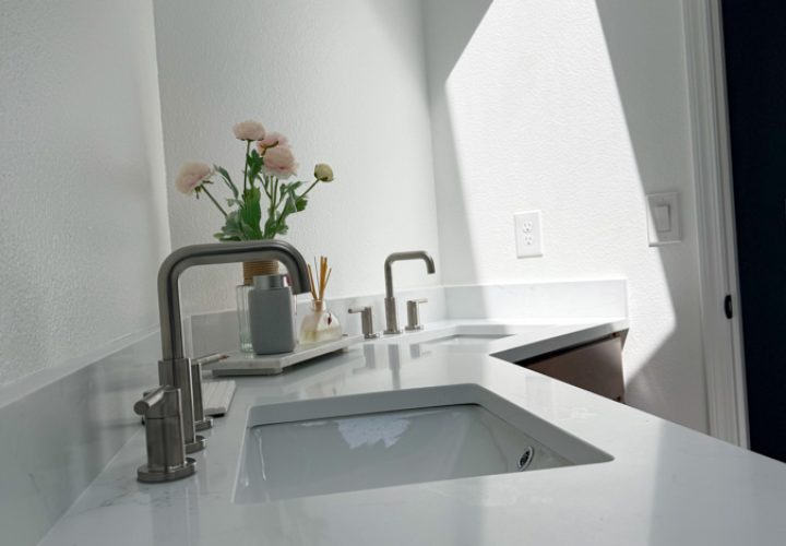 A modern sink with a sleek design, integrated under-cabinet lighting, and a vase of fresh flowers for a touch of elegance.