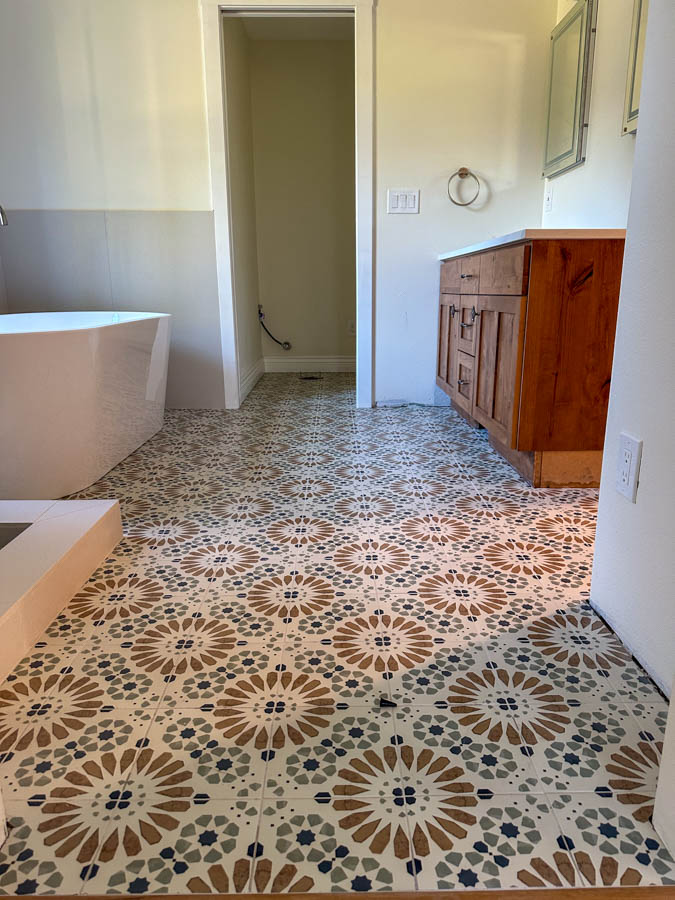 A vibrant bathroom floor covered in patterned ceramic tiles with intricate designs, adding warmth and character to the space.